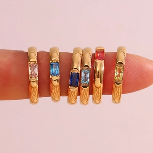 Set di sei anelli in acciaio dorato con zirconi rettangolari colorati mostrati sulla mano