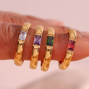 Dettaglio macro di anelli placcati in oro 18K con pietre di zircone rettangolari colorate