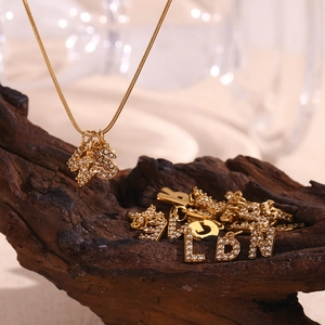 Macro view of 18K gold plated snake chain necklaces with sparkling crystal initial pendants