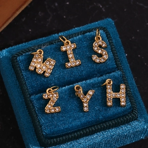 Detail of 18K gold plated letter pendants M, I, S, Z, Y, H with pavé set crystals