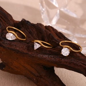 Detailed macro of three gold 18K rings with pear, triangle, and round zircon stones