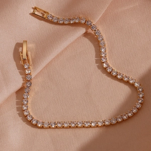 Elegantes 18K vergoldetes Tennisarmband mit runden Zirkonia auf Seidenhintergrund