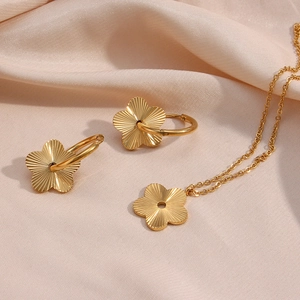 Detailed view of gold plated 18K stainless steel floral jewelry set on champagne silk