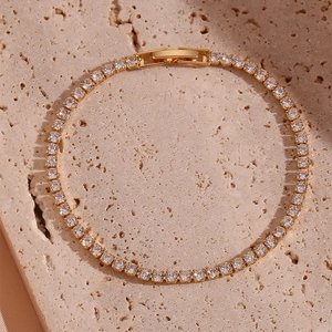 Detaillierte Draufsicht eines vergoldeten Tennisarmbands mit Zirkonia-Steinen auf Stein