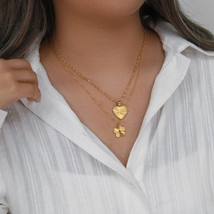 Double-layered 18K gold plated necklace featuring heart and flower charms on a model