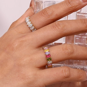 Close-up of golden oval zircon rings in clear white and colorful multi-gemstone styles