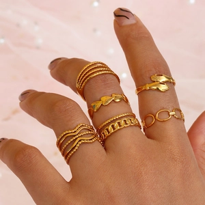 Nahaufnahme eines 6-teiligen minimalistischen Goldring-Sets mit Herz und Knoten
