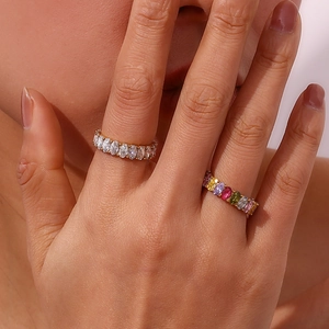 Detailed view of two gold rings with oval-cut zircons and multi-color marquise stones