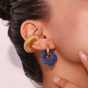 Detail of 18K gold-plated spiral ear cuff and translucent blue flower drop earring