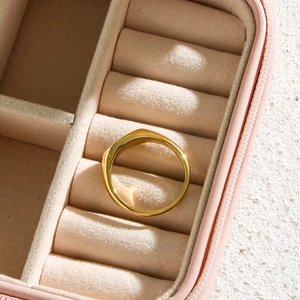 Detailed top view of a high-polished 18K gold plated oval signet ring in a pink velvet box