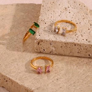 Vue détaillée de trois bagues dorées ornées de pierres de zircone vertes, blanches et roses