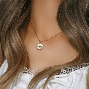 Gros plan d'un collier doré avec pendentif étoile porté par un mannequin en dentelle