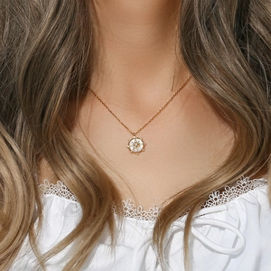 Collier étoile boussole dorée avec nacre et zircon porté sur le cou d'un mannequin