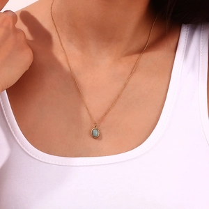 Détail du pendentif ovale vintage plaqué or 18K avec pierre naturelle bleue sur modèle