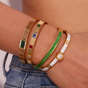 Detailed view of layered 18K gold plated bangle set with green zircon and gemstones