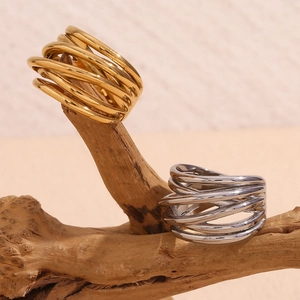Macro view of woven intertwining rings in gold and silver finish on natural wood base