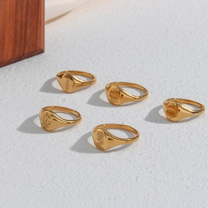 Detailed view of five gold signet rings with engraved sunflower and lavender patterns