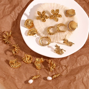 Macro detail of 18K gold plated earrings with pearls and geometric texture details