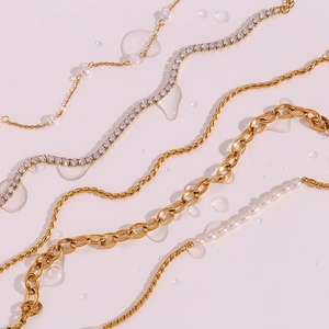 Detailed view of layered gold anklets featuring freshwater pearls and zircon tennis chains