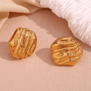 Macro shot of 18K gold plated stainless steel stud earrings with geometric fluid texture