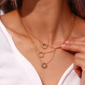 Detailansicht der dreilagigen Goldkette mit gedrehten Ringen und bunten Anhängern