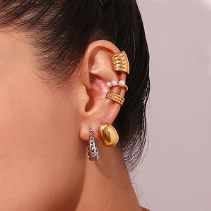 Detailed close-up of 18K gold-plated stainless steel earrings and ear cuffs on a model