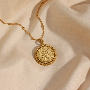 Close-up of 18K gold-plated star pendant necklace on champagne satin fabric
