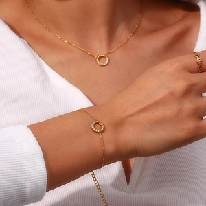 Detail eines eleganten Goldschmuck-Sets mit Zirkonia-Anhängern getragen von einem Model