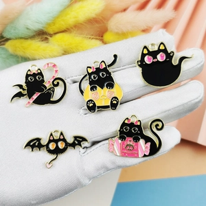 Halloween emaille bedeltjes met zwarte katten in diverse stijlen op een hand