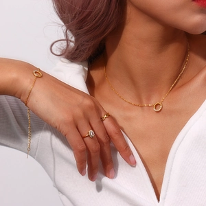 Nahaufnahme eines goldenen Schmucksets mit Pavé-Anhänger-Halskette und Blumen-Ringen