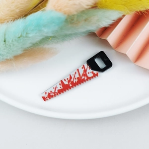 Vue détaillée d'une mini scie sanglante pour la création de bijoux DIY d'Halloween