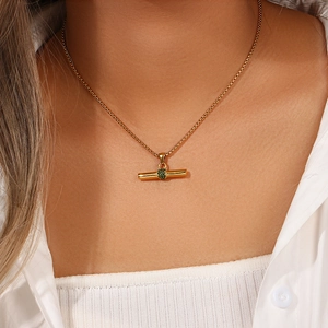 Detail einer 18K vergoldeten T-Bar-Halskette mit grüner Zirkonia-Mikrofassung am Model