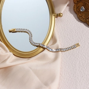 Detail of 18K gold plated tennis bracelet with sparkling baguette-cut zircons on silk