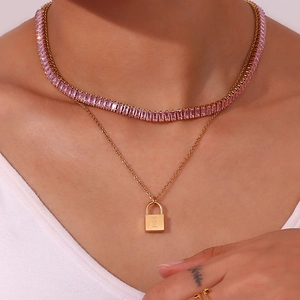 Nahaufnahme der 18K vergoldeten Doppelhalskette mit rosa Kristallen und Schlossanhänger