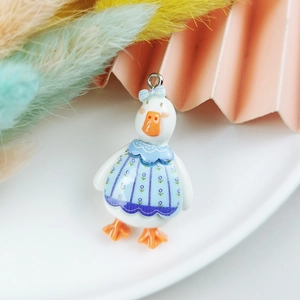 Detailansicht eines niedlichen Enten-Anhängers aus Harz mit blauem Blumenkleid und Ring