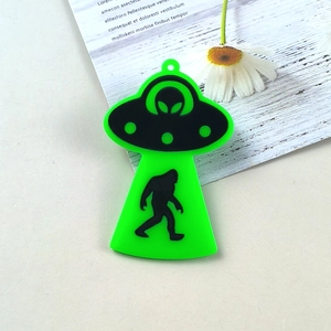 Nahaufnahme von neongrünem UFO-Acrylanhänger mit Bigfoot-Silhouette für DIY-Schmuckbau