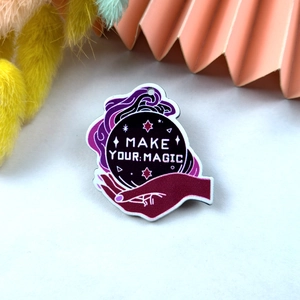 Detail of acrylic magic crystal ball charm with Make Your Magic text and purple star decor