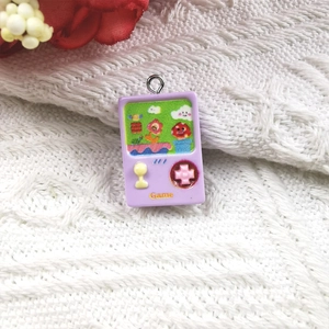 Macro shot of purple resin retro game console charm on white knit fabric