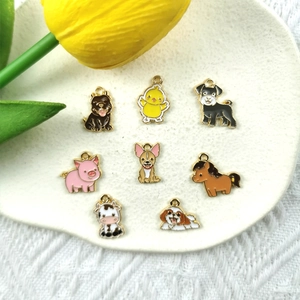 Ocho coloridos colgantes de animales en esmalte en un plato de cerámica para joyas DIY