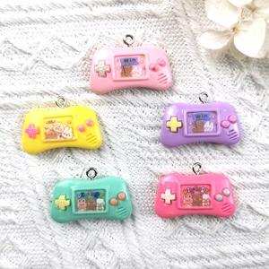Colorful retro game controller resin charms with metal loops on white knit fabric
