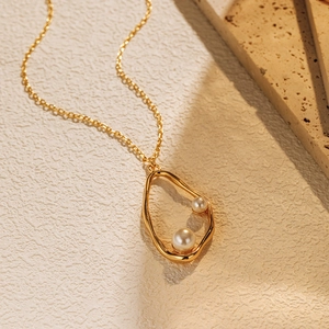 Vue macro du collier plaqué or avec cadre irrégulier et perles blanches élégantes