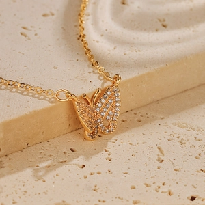 Détail macro du collier pendentif papillon plaqué or serti de zircons