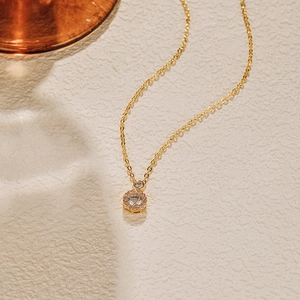 Détail d'un collier plaqué or avec un pendentif rond orné d'une grande pierre de zircon
