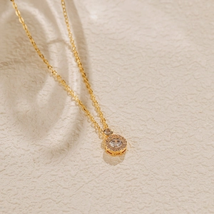 Détails d'un collier pendentif doré avec incrustation de zircons cubiques scintillants