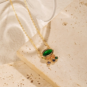 Détail d'un collier pendentif œil plaqué or avec marquise verte et pierres multicolores