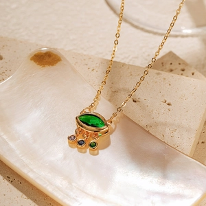 Détail du collier œil en plaqué or avec pierre verte et zircons colorés élégants