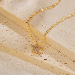 Détail d'un collier pendentif étoile de mer plaqué or avec cristaux de zircon micro-pavés