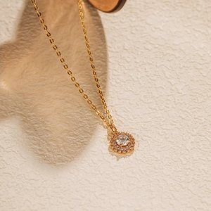 Vue détaillée d'un collier avec pendentif halo doré et zircon rond étincelant de luxe