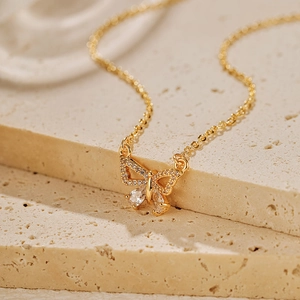 Gros plan d'un collier papillon doré serti de zircons et de pierres en forme de goutte