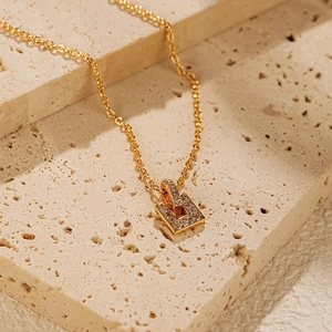 Gros plan détaillé d'un pendentif rectangulaire doré avec micro-pavage de zircons sur pierre